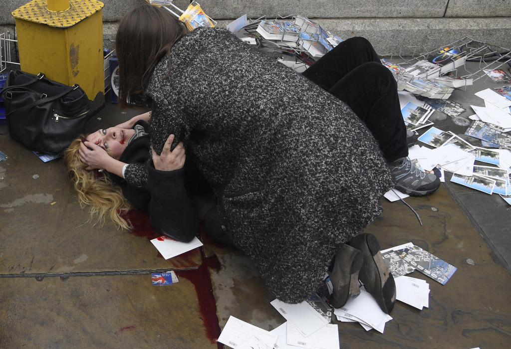 Witnessing the Immediate Aftermath of an Attack in the Heart of London © Toby Melville, Reuters // A passerby comforts an injured woman lying on the pavement after Khalid Masood drove his car into pedestrians killing four in addition to a police officer at Westminster Bridge in London, Britain, March 22, 2017.